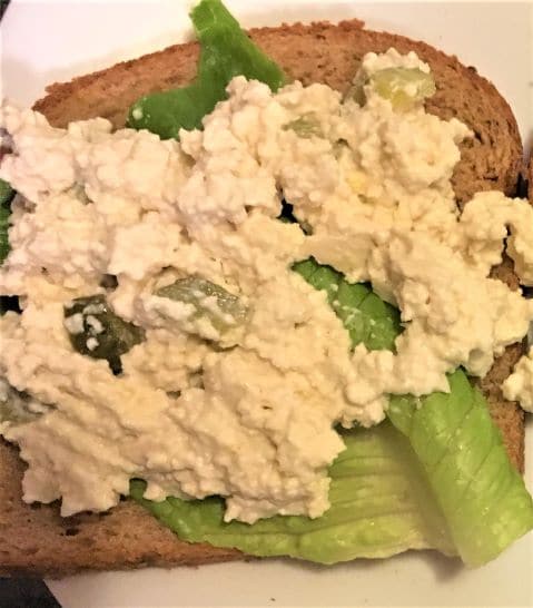 Picture of tofu egg salad on with a leaf of romaine lettuce on bread