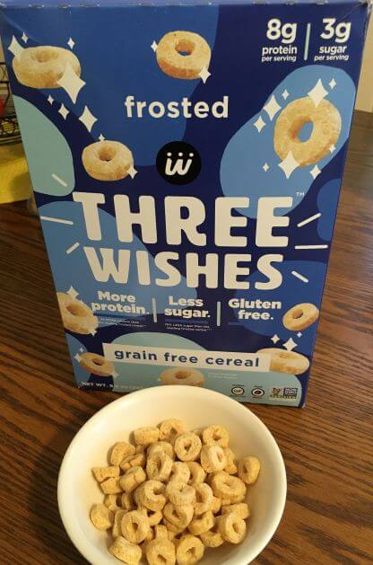 Picture of Three Wishes Frosted cereal box, along with a bowl and some of the cereal in it.