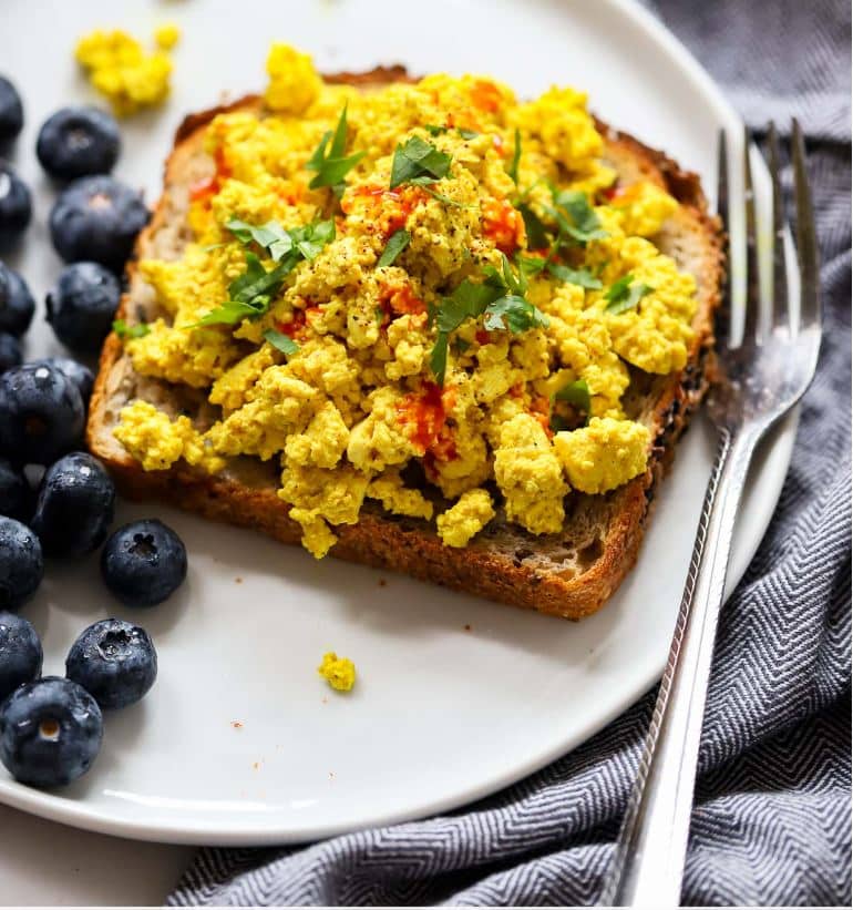 picture of toast with tofu scramble on top and blueberries on the side