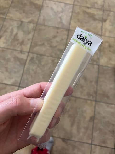 hand holding one daiya cheese stick